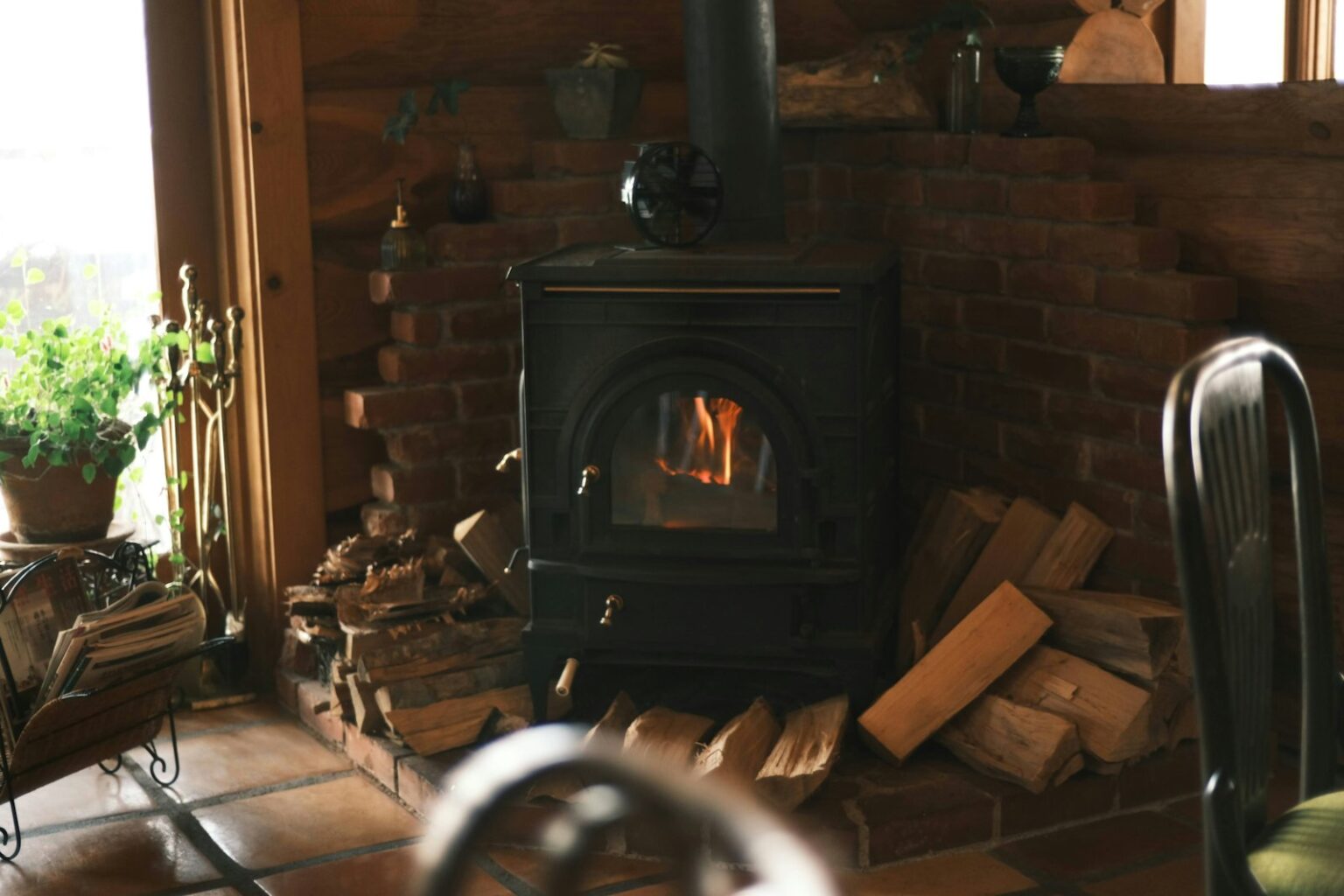Combien de sacs de pellets faut-il pour passer l’hiver ? Poêle à granulés de bois allumé dans un salon en hiver